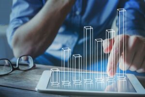 Photo illustration of a person manipulating a 3D bar graph