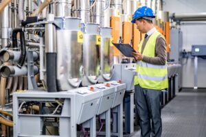 A worker inspects some machinery in a factory
