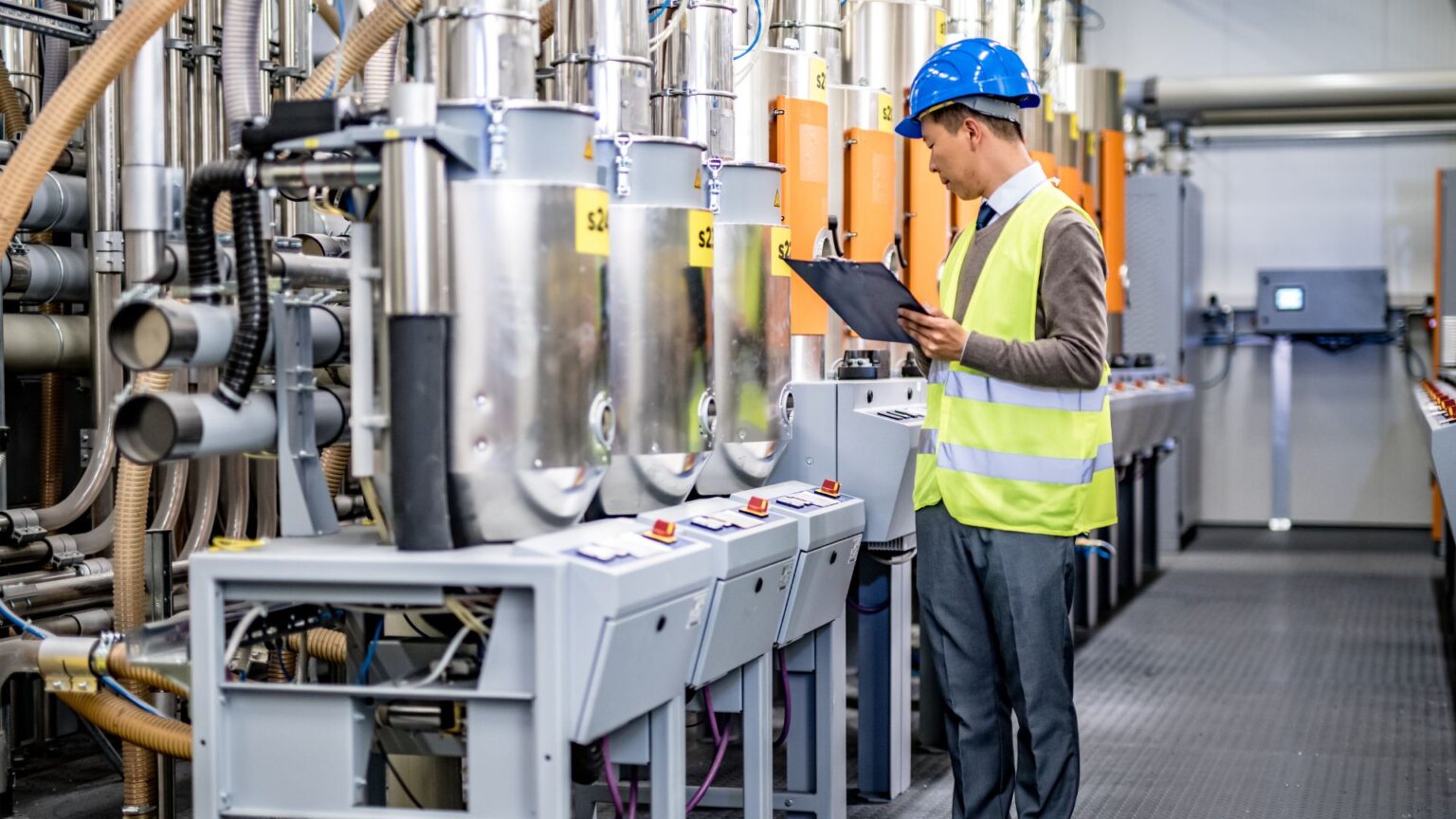 A worker inspects some machinery in a factory