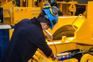 Worker operating manufacturing equipment