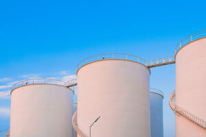 Group of chemical storage tanks against a bright blue sky