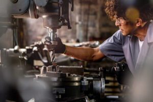 Men are inspecting steel parts for machine installation