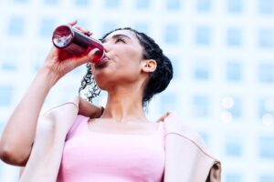 Young woman in fitness gear drinking an energy drink