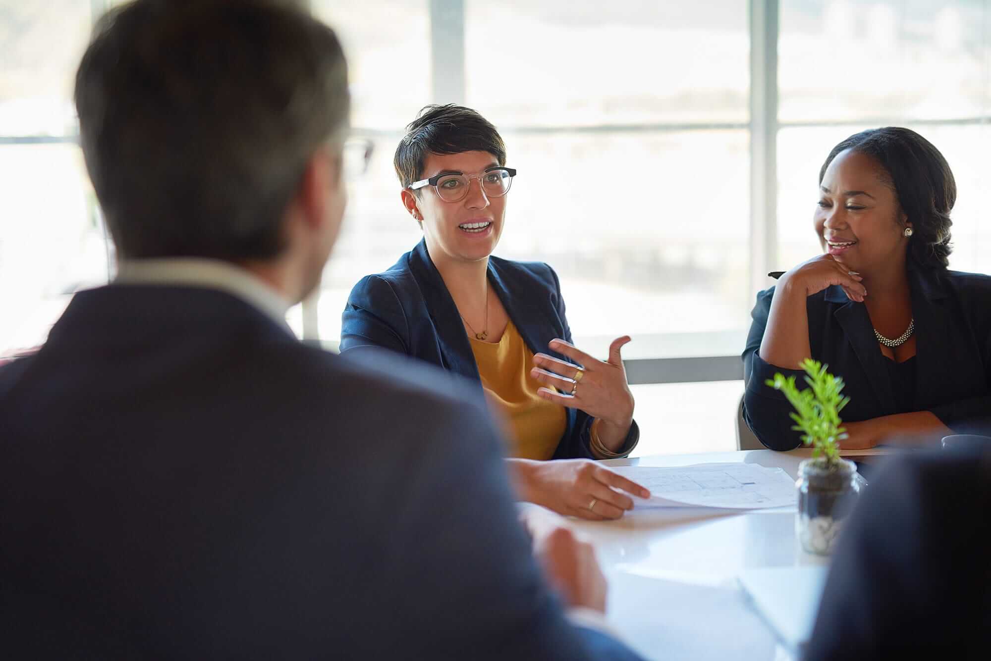 A woman pitches an idea to a boardroom of businesspeople