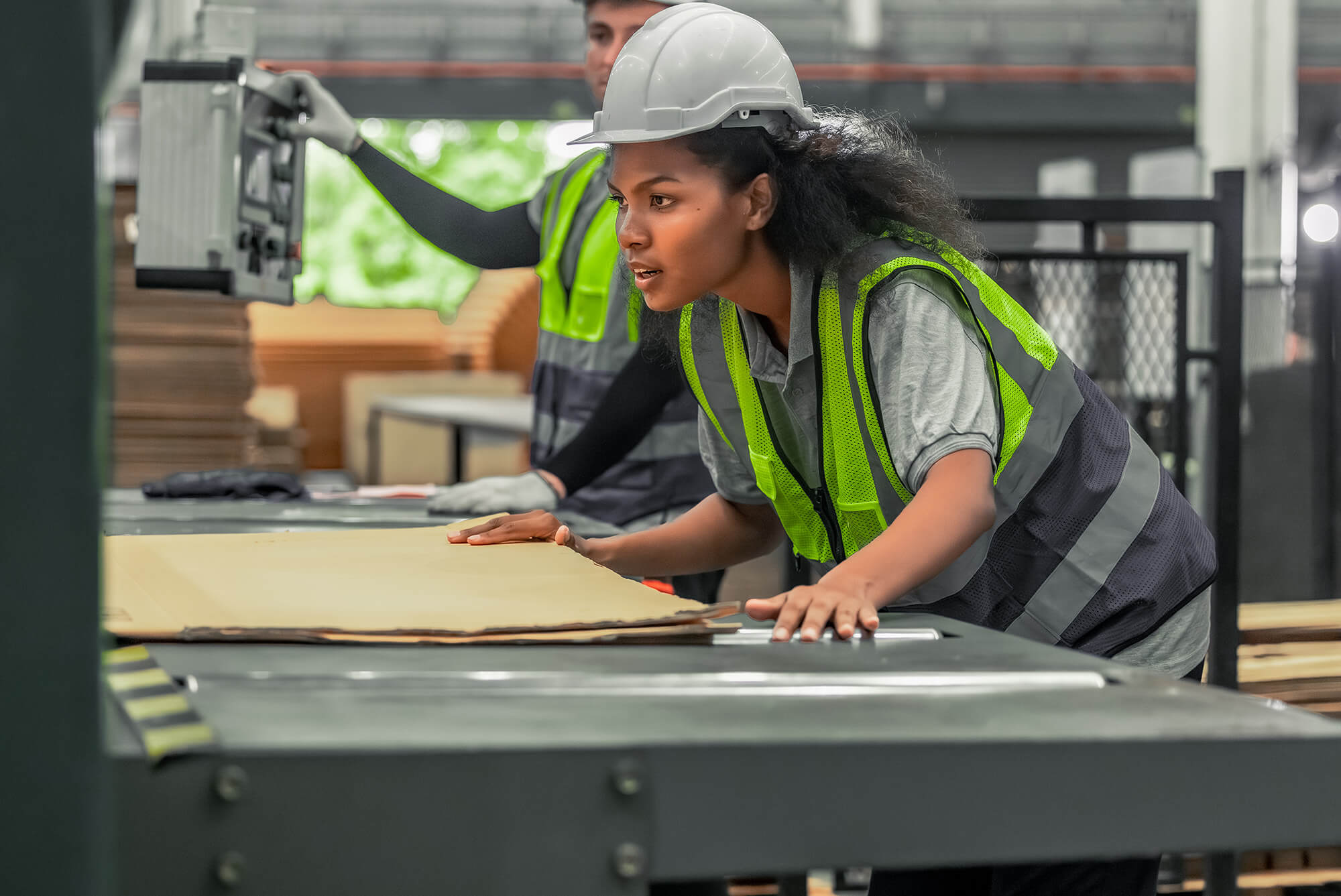Technician inspecting a machine in a cardboard factory